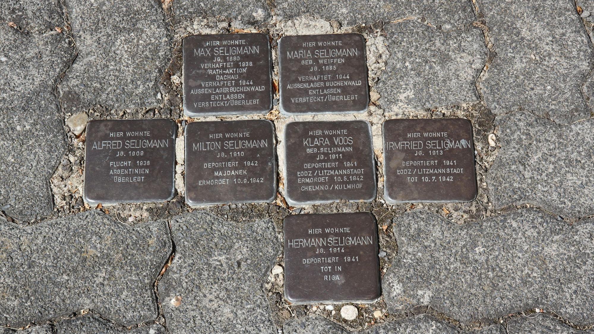 Sieben Stolpersteine zur Erinnerung an jüdische Opfer der NS-Diktatur zwischen Pflastersteinen