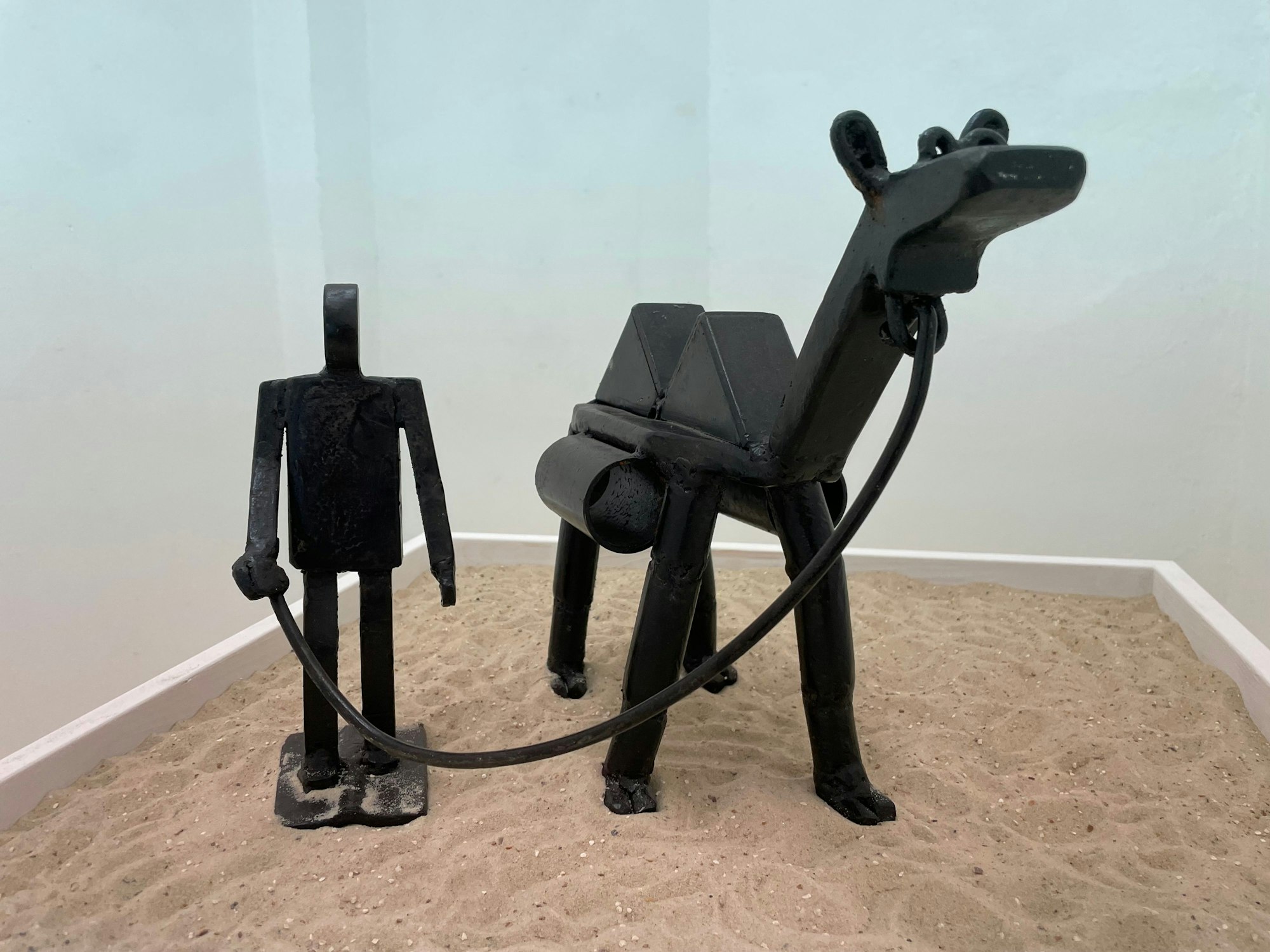 Eine künstlerische Metallkonstruktion auf Sand.