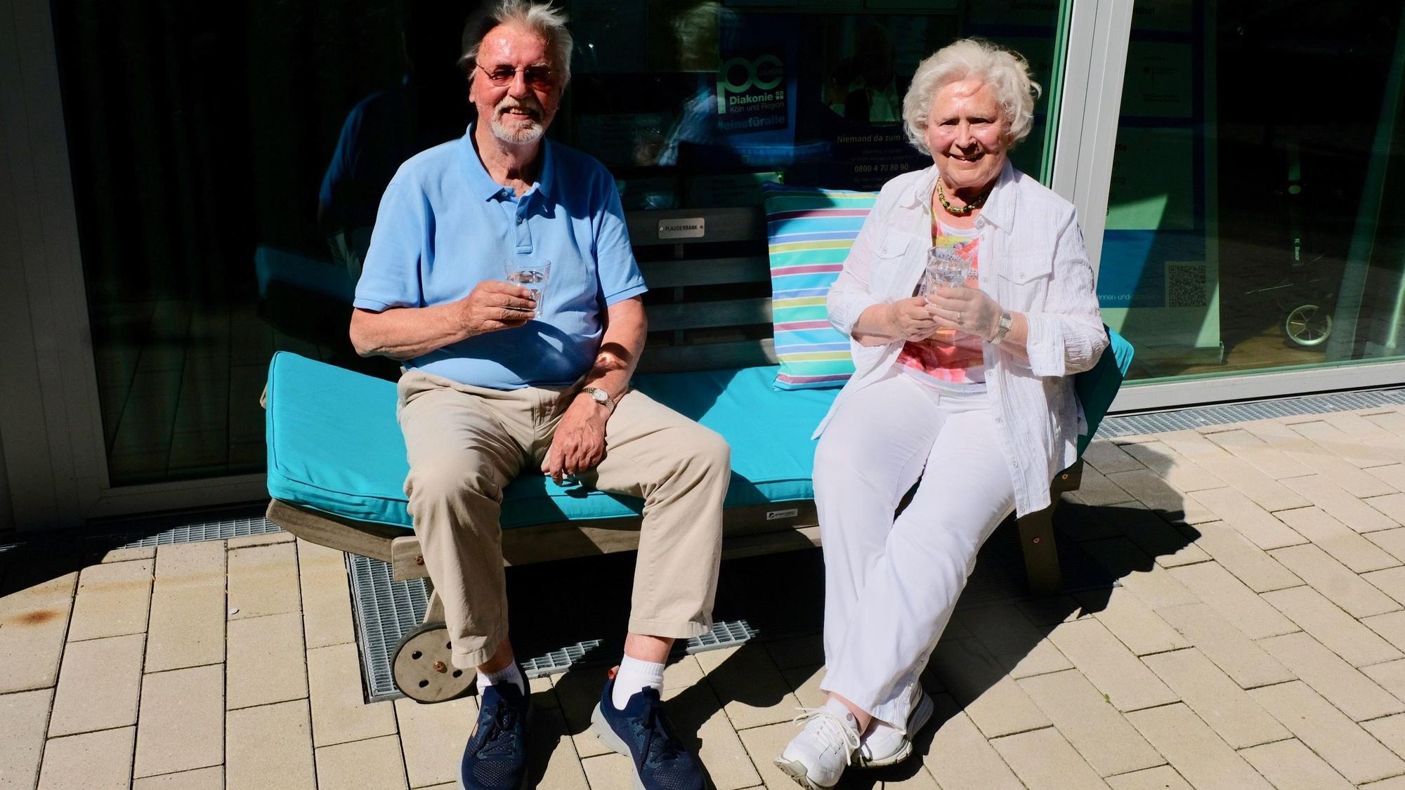 Ein Senior und eine Seniorin auf der Plauderbank vor dem Raum an der Palanterstraße 13.