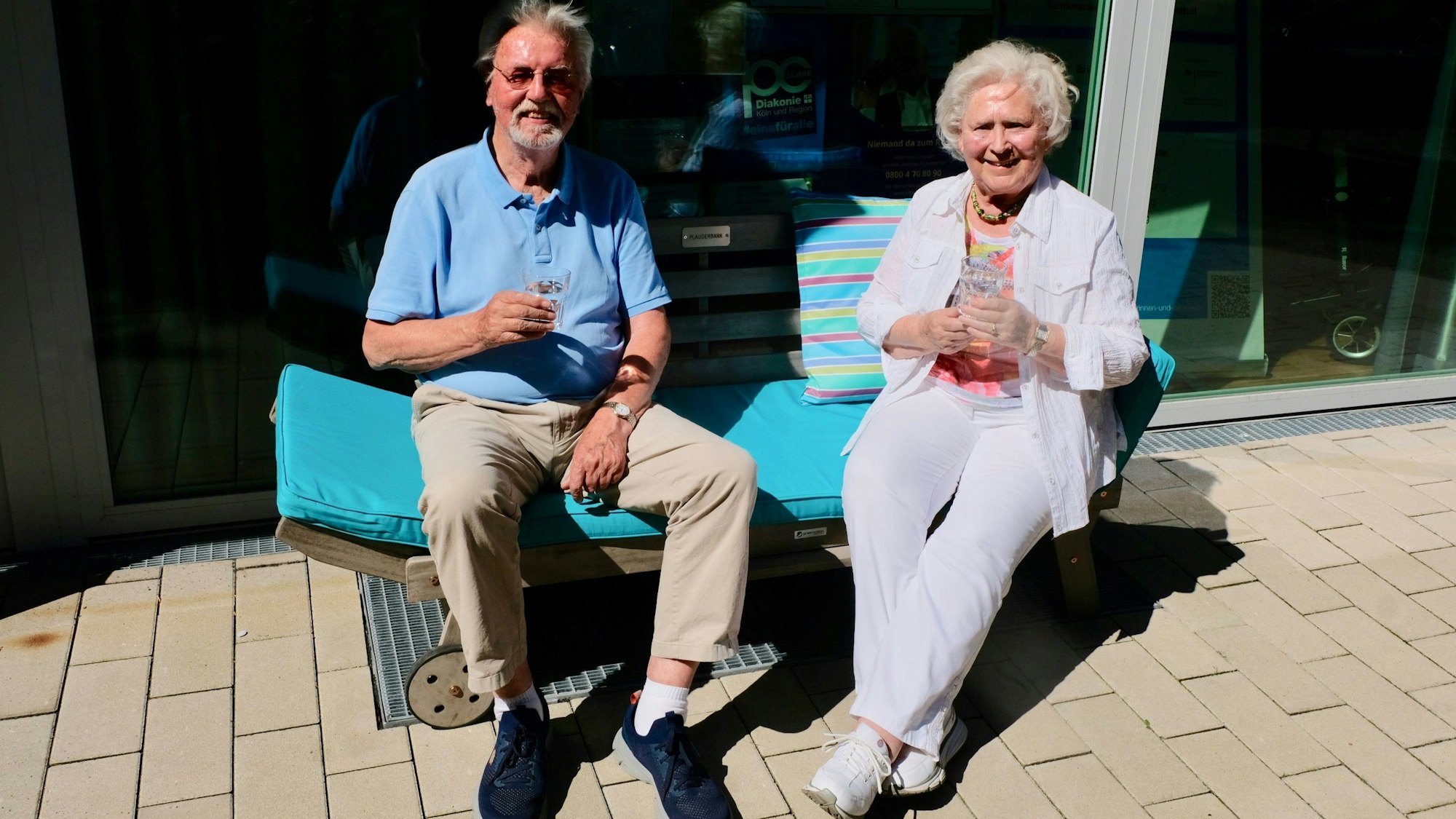 Ein Senior und eine Seniorin auf der Plauderbank vor dem Raum an der Palanterstraße 13.
