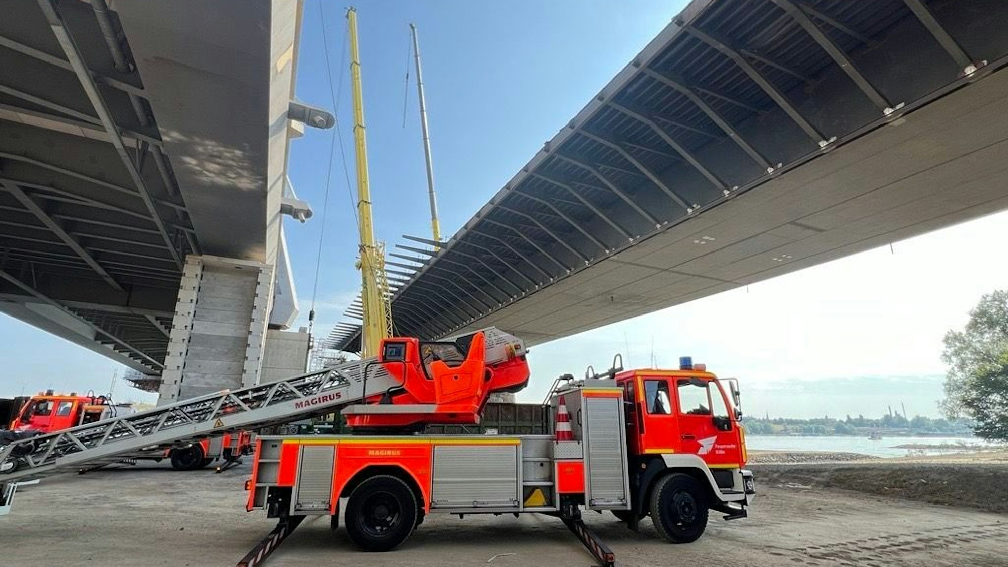 Ein Feuerwehrwagen steht unterhalb der alten und neuen Autobahnbrücke zwischen Köln und Leverkusen.