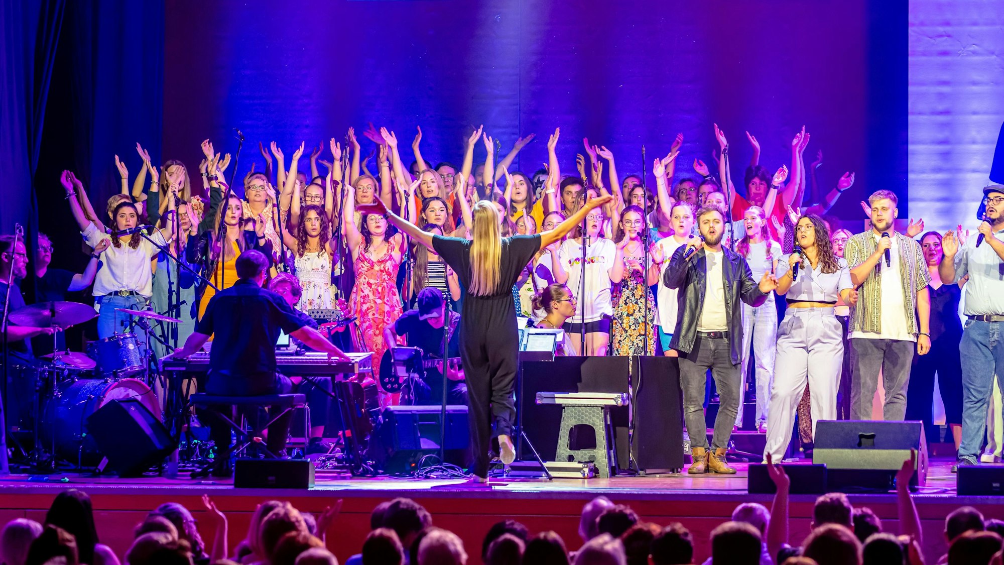 Ein Chor singt auf einer Bühne.