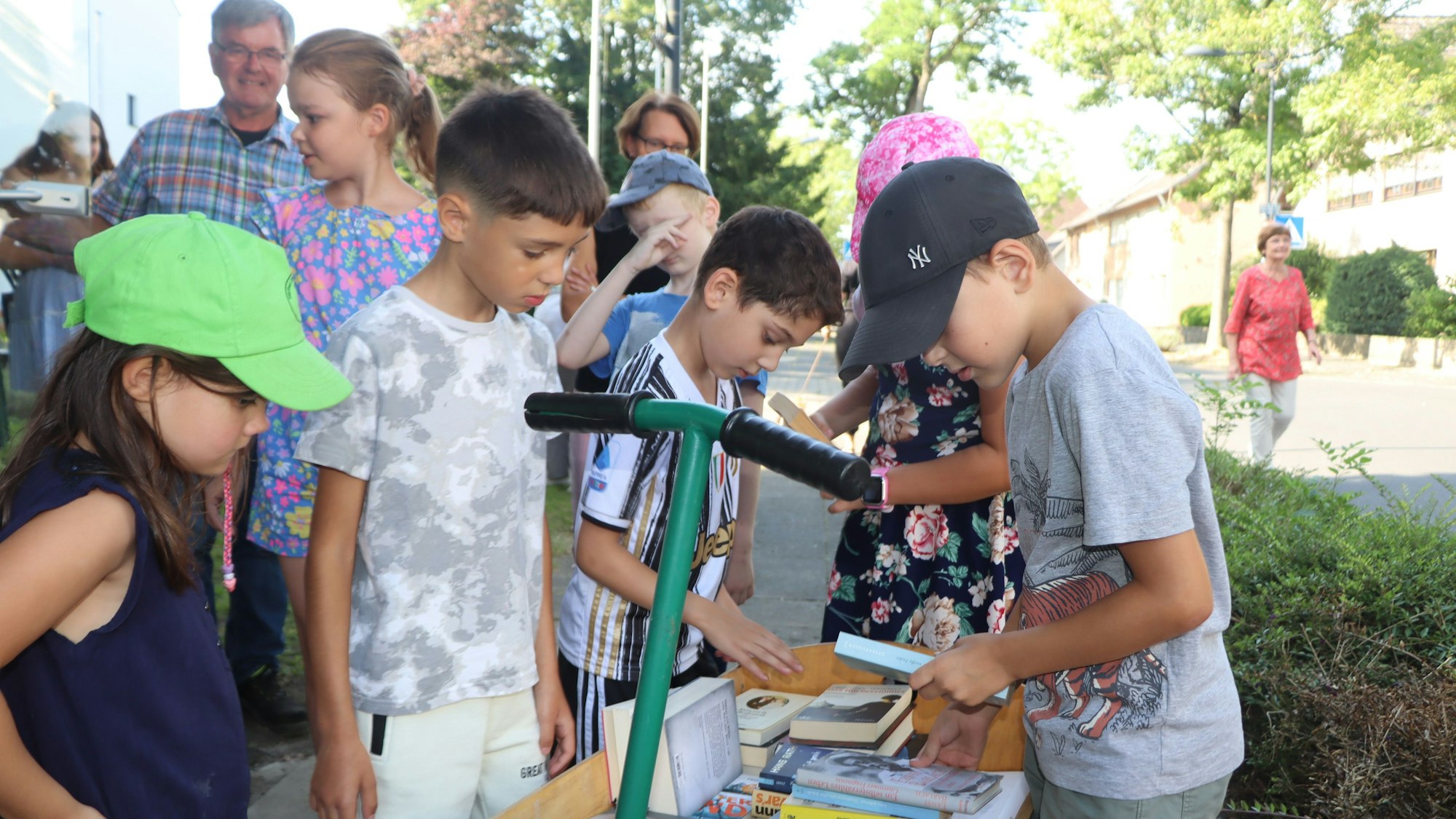 Auf dem Bild sind Kinder zu sehen, die Bücher sortieren.