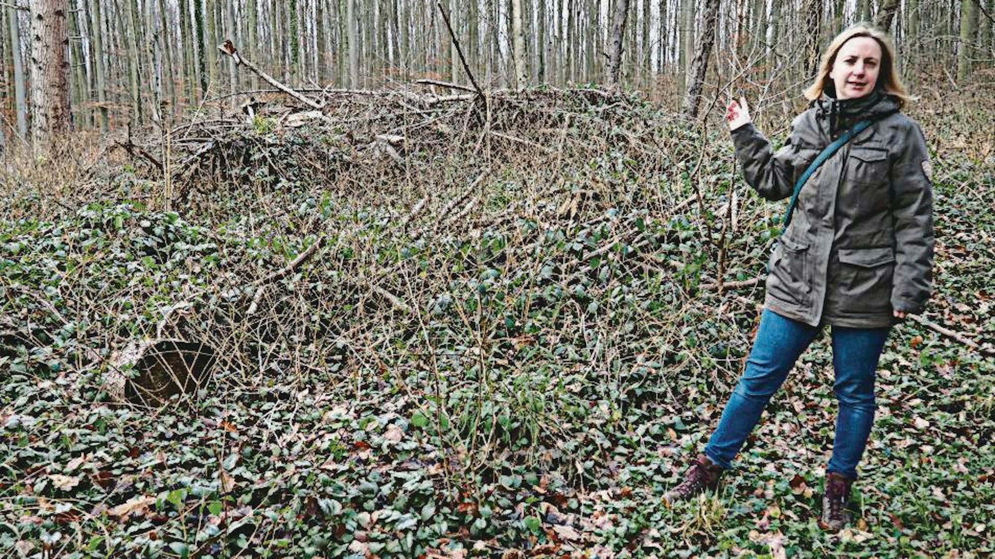 Die Biologin Christine Thiel-Bender steht in einem Wald und erklärt, wo sich Wildkatzen wohlfühlen.