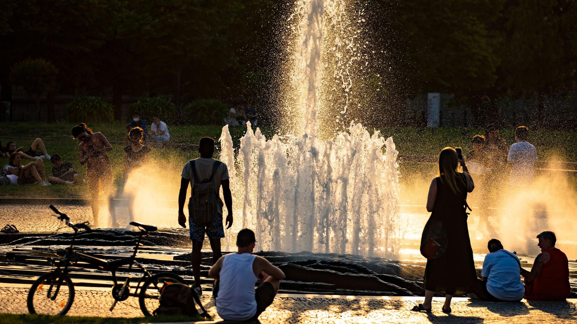 Menschen bei dem Brunnen im Lustgarten auf der Museumsinsel in Berlin am 20. Juli 2022.