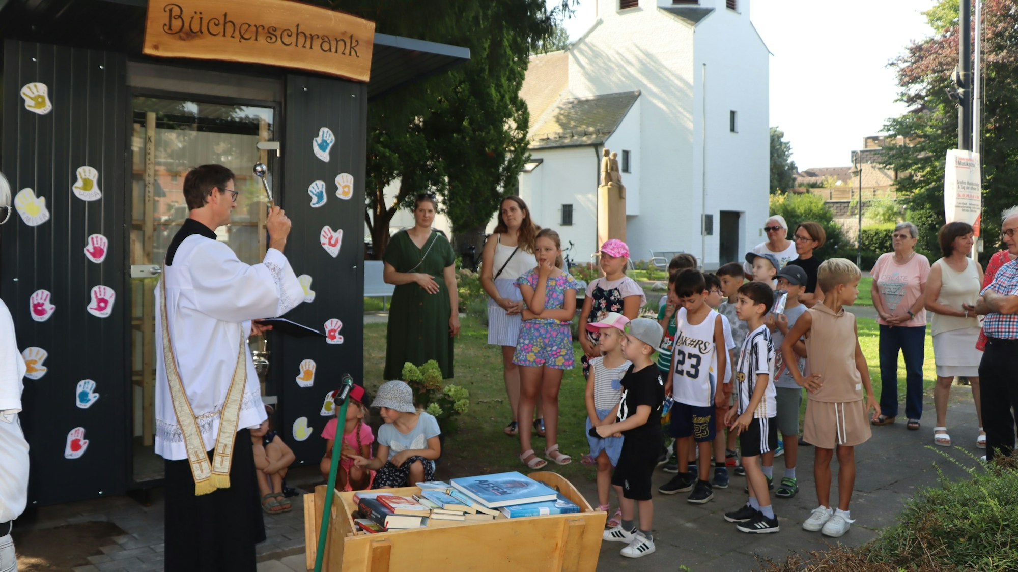 Auf dem Bild ist die Einsegnung des neuen Bücherschrankes zu sehen.