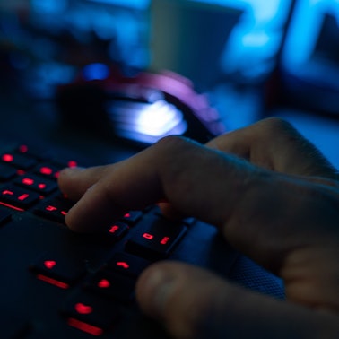 Ein Mann sitzt am Rechner und tippt auf einer Tastatur.