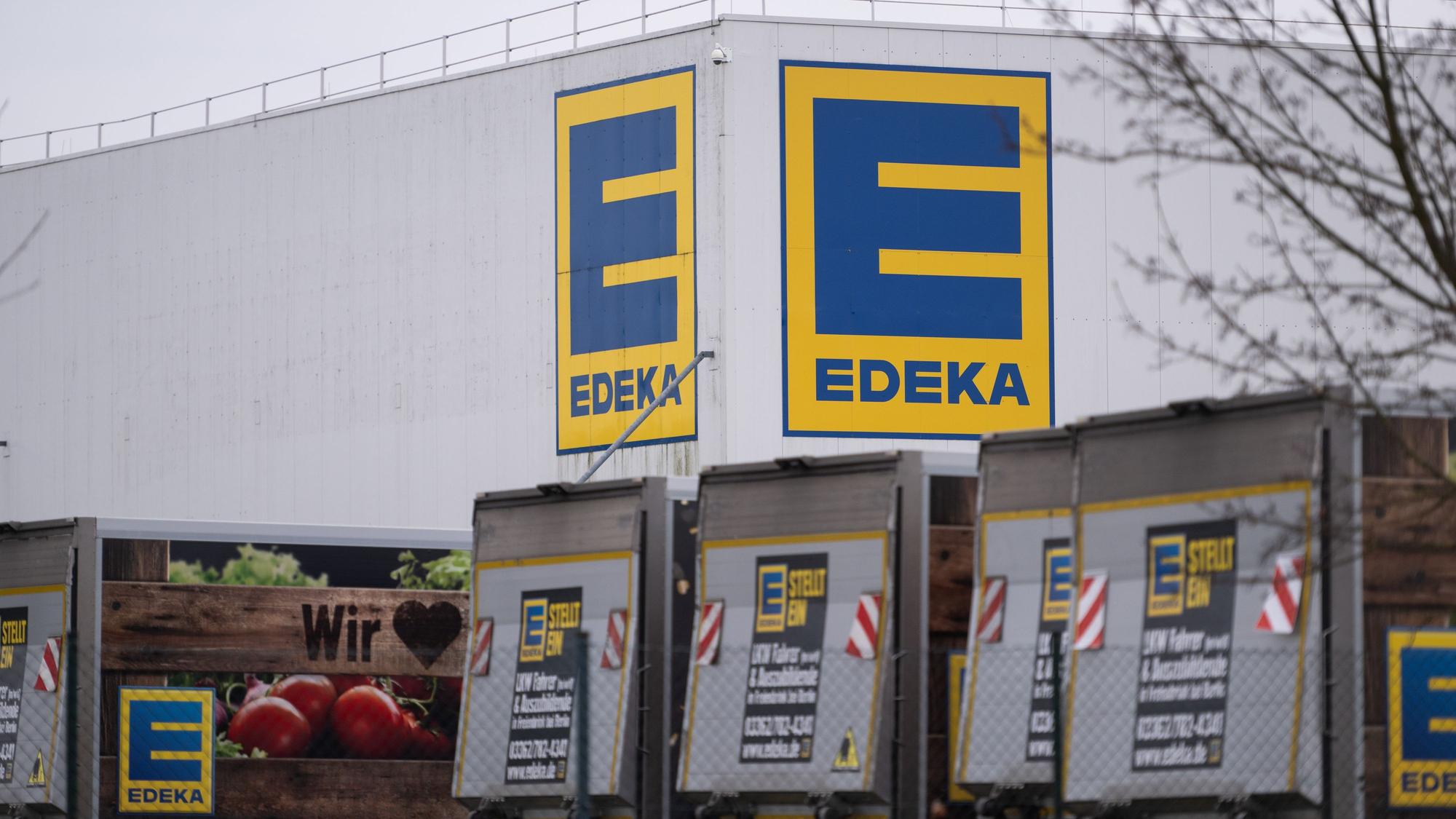 Vor einem Logistikzentrum der Handelskette Edeka stehen mehrere LKW.