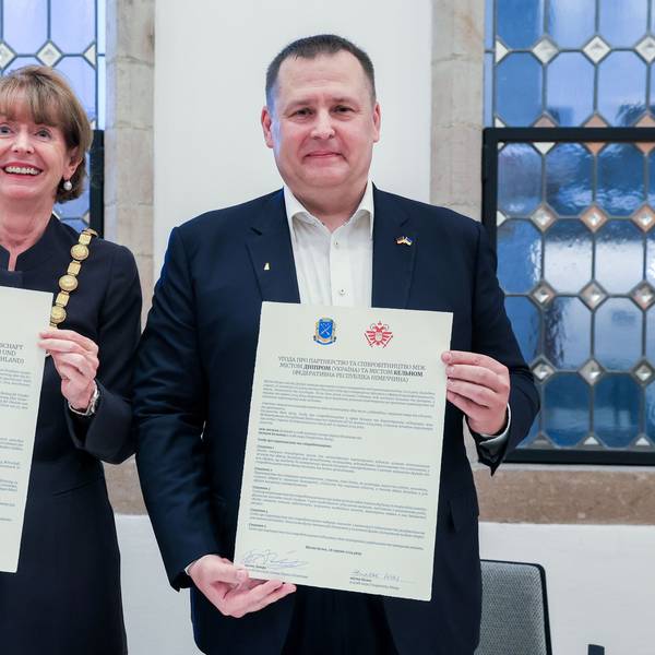 Zu sehen ist Henriette Reker mit Dnipros Bürgermeister Boris Filatov, die Urkunden in den Hälten halten, in der Vorderansicht.