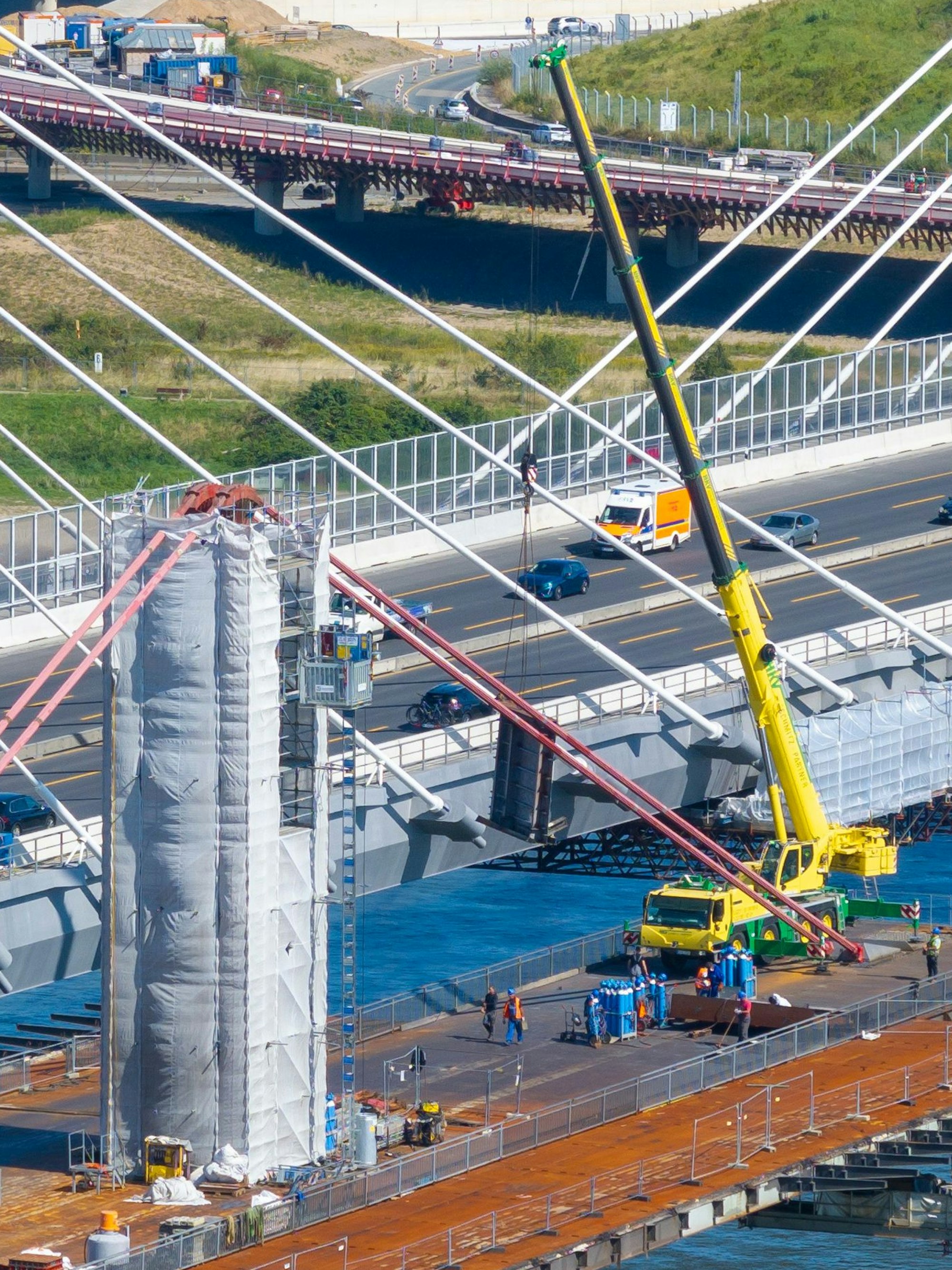 Ein Tag vor dem tödlichen Unglück: Der Kran hilft bei den Abrissarbeiten des alten Pylons. Über dem Pfeiler sind noch die roten Tragseile der alten Brücke gespannt.