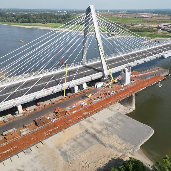 Bei Abrissarbeiten des alten Brückenbauteils durch den Autokran geschah das Unglück. Der Kran wurde durch die abgestürzten roten Tragseile der Brücke beschädigt.