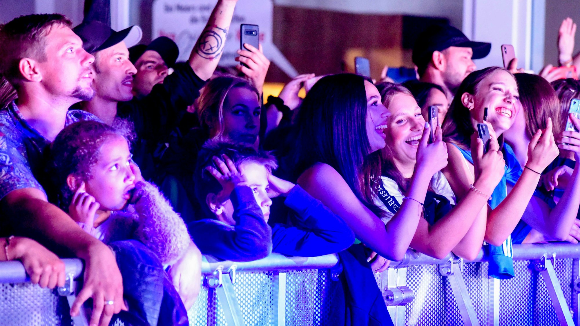 Das Foto zeigt junge Besucherinnen und Besucher hinter dem Absperrgitter vor der Bühne.