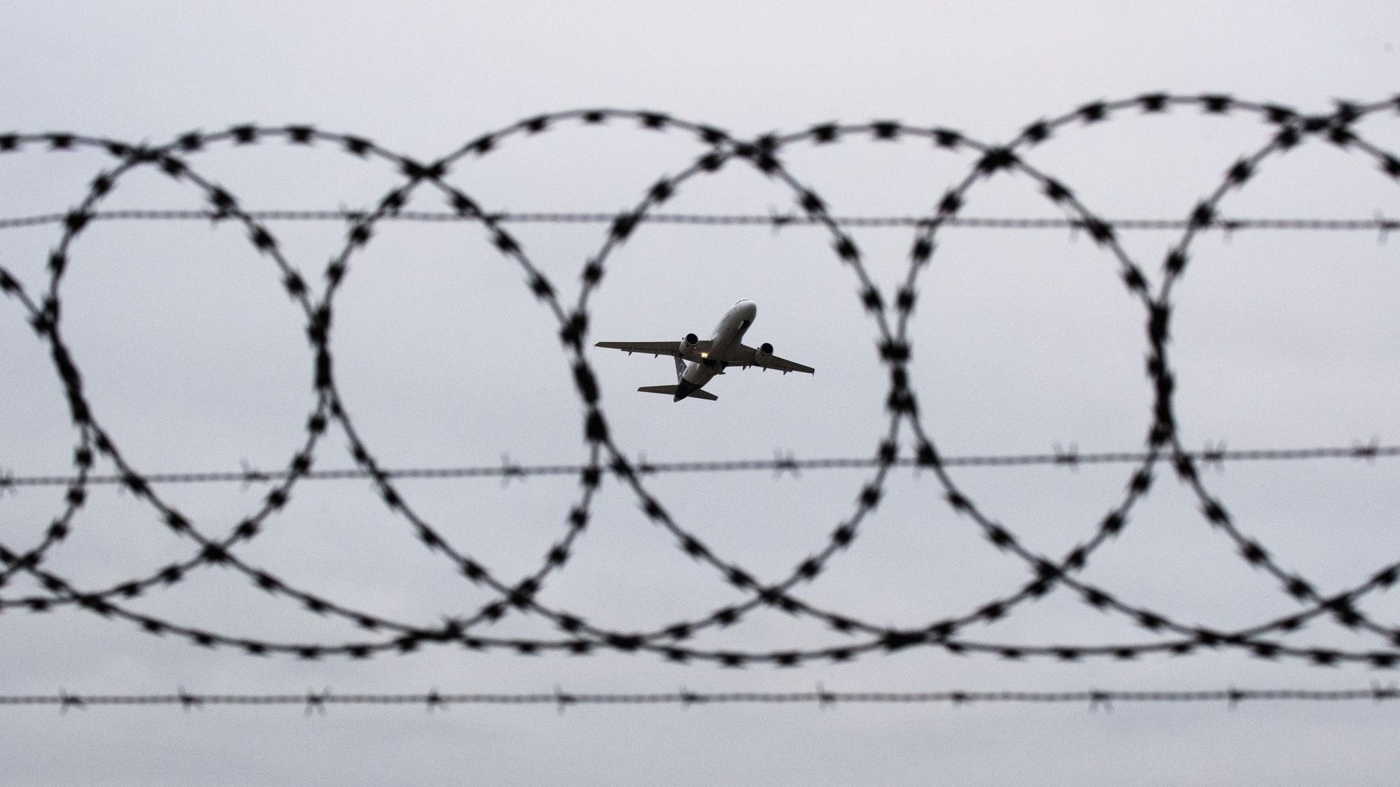 ARCHIV - 06.01.2020, Niedersachsen, Hannover: ILLUSTRATION - Ein Flugzeug startet - fotografiert durch Stacheldraht am Flughafenzaun. (zu dpa: «Klingbeil: Alles prüfen, was der Sicherheit hilft») Foto: Julian Stratenschulte/dpa +++ dpa-Bildfunk +++