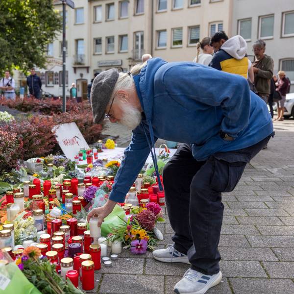 Solingen: Der Organisator der Jubiläums-Feier stellt im Gedenken an die Opfer eine Kerze auf.