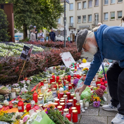 Solingen: Der Organisator der Jubiläums-Feier stellt im Gedenken an die Opfer eine Kerze auf.