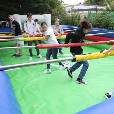 Junge Leute spielen Menschenkicker.