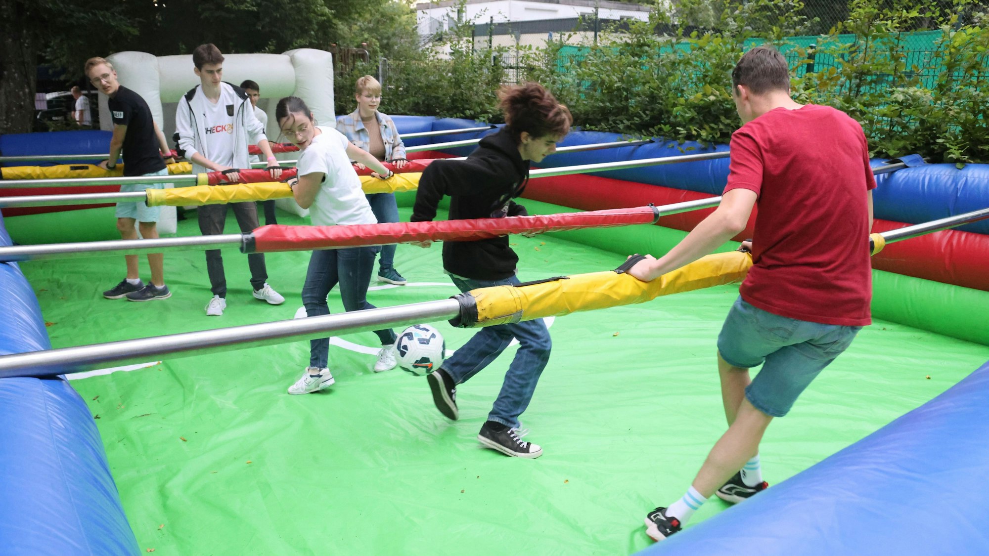 Junge Leute spielen Menschenkicker.