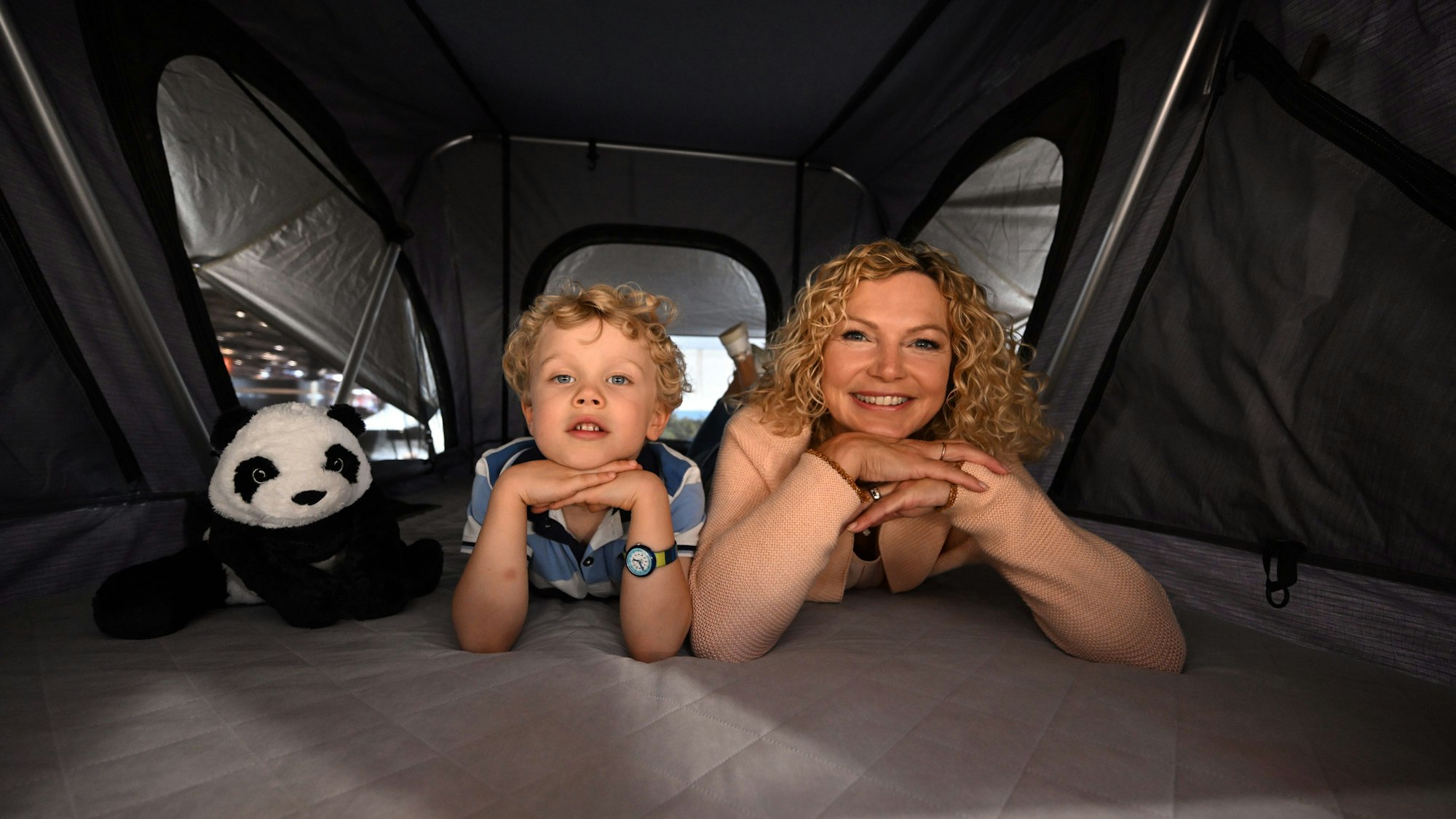 Die Models Anton (l.) und Anja liegen in einem Moonlight Dachzelt der Firma Fiamma.