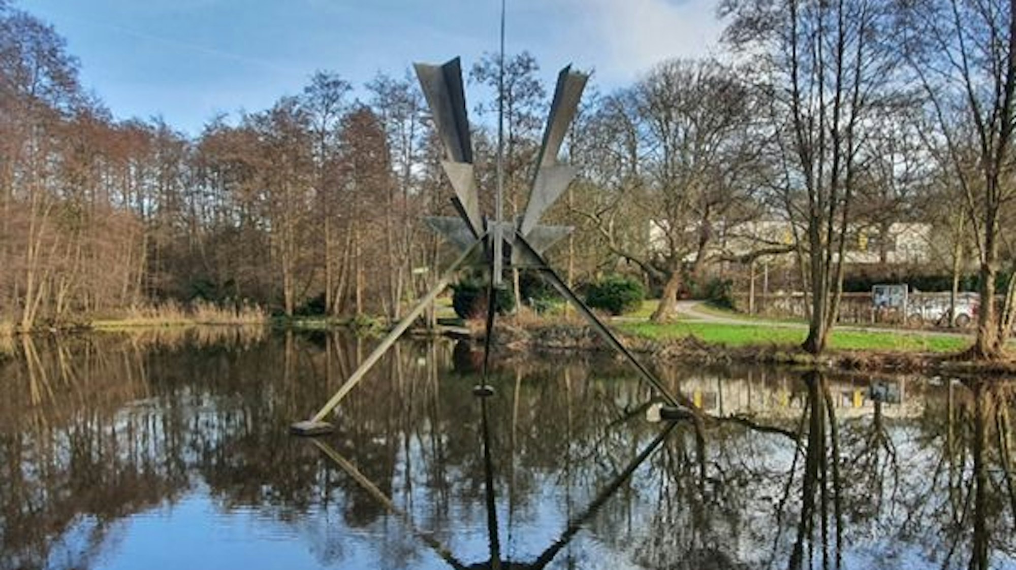 Eine Metallskulptur steht in einem Weiher.