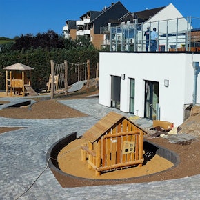 Auf dem Außengelände einer Kita arbeitet ein Handwerker.