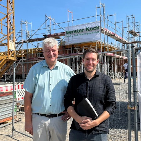 Nümbrechts Bürgermeister Hilko Redenius und Fachbereichsleiter Jan Förster stehen vor einem Gebäude, das gerade gebaut wird.