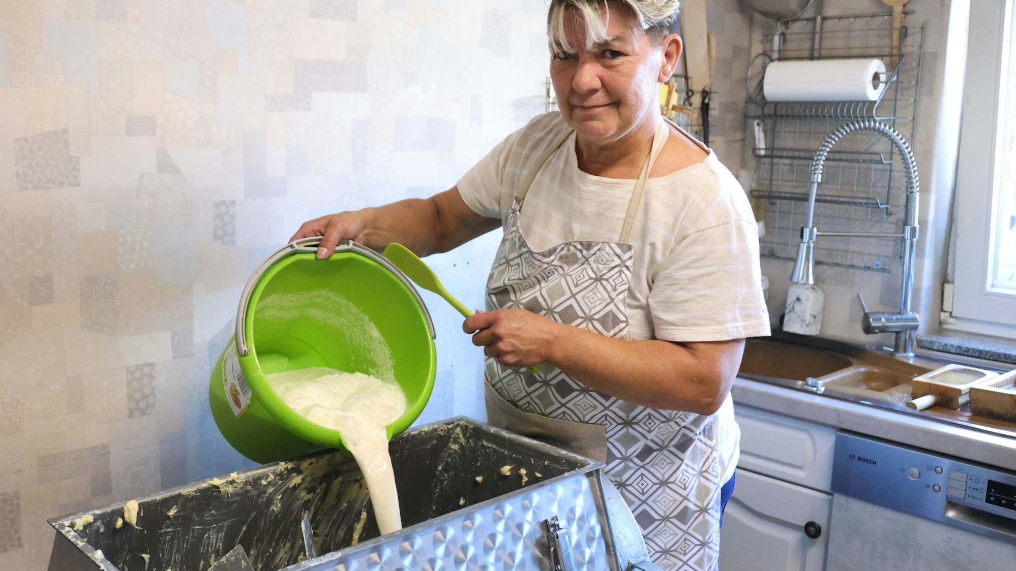 Sabine Greb schüttet Schmand in das Rührwerk, das diesen dann zu „guter Butter“ verarbeitet. Dieses Handwerk ist auf dem Hof von Sabine und Jürgen Greb in Waldbröl-Hermesdorf eine Familientradition. Deren Tage aber sind gezählt.