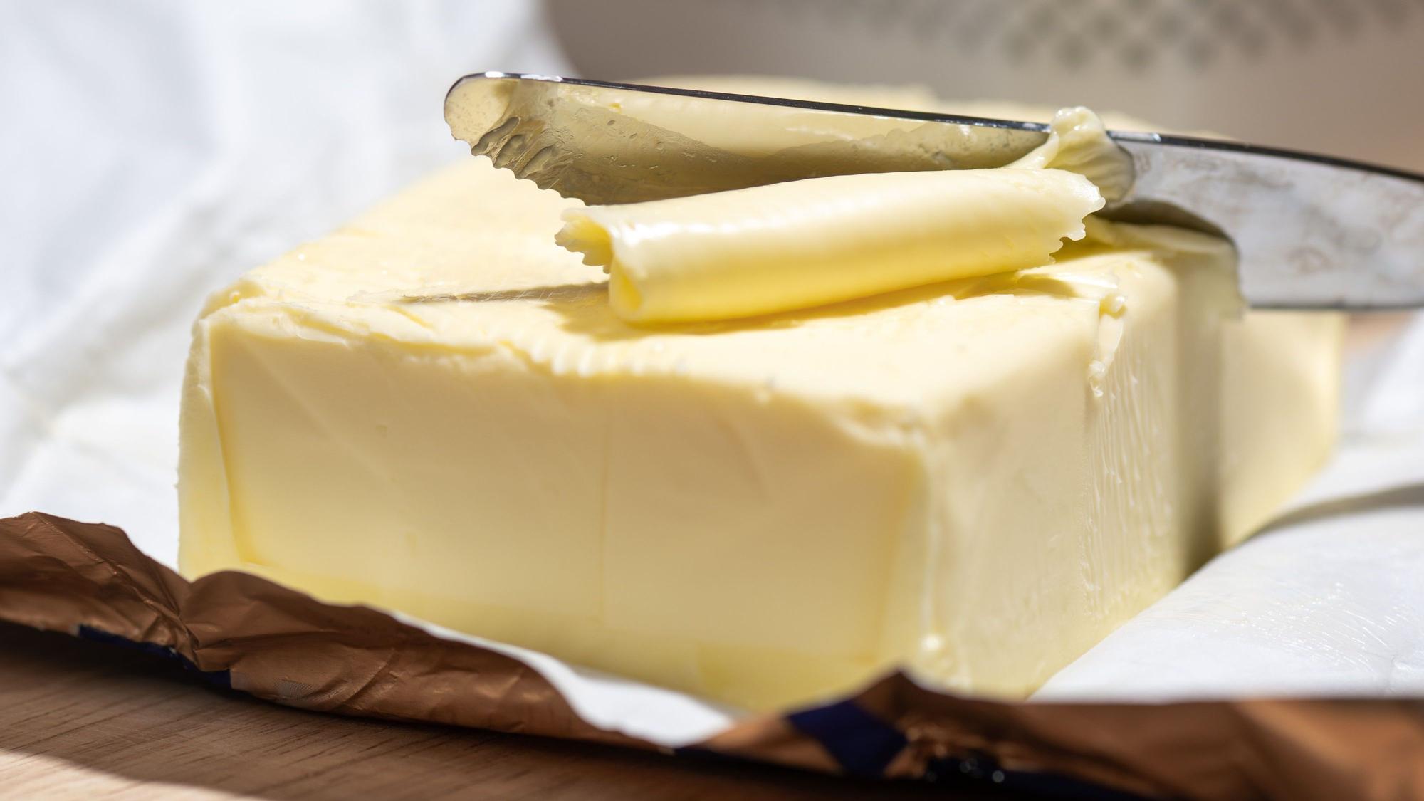 Ein Stück Butter liegt auf einem Tisch. (Symbolbild)