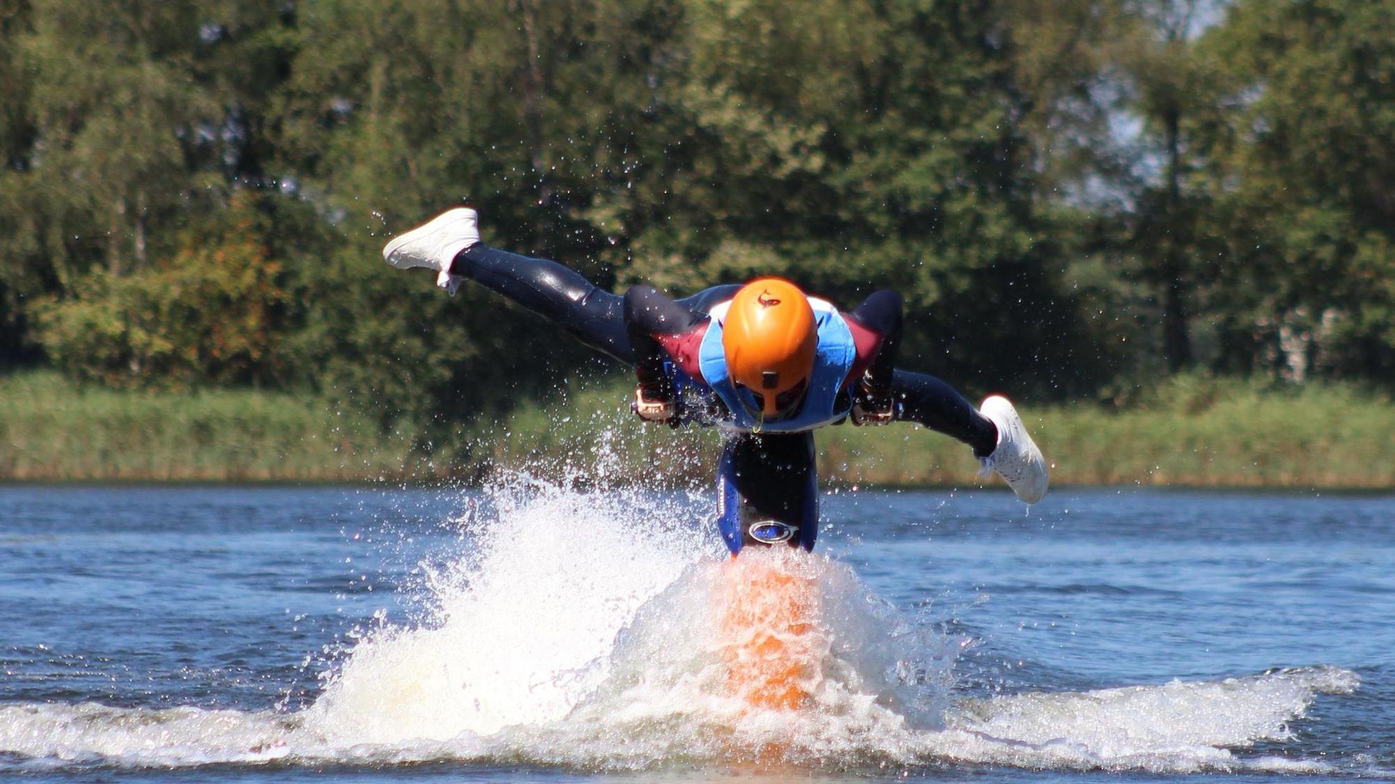 Eine junge Frau führt Kunststücke auf einem Jetski vor.