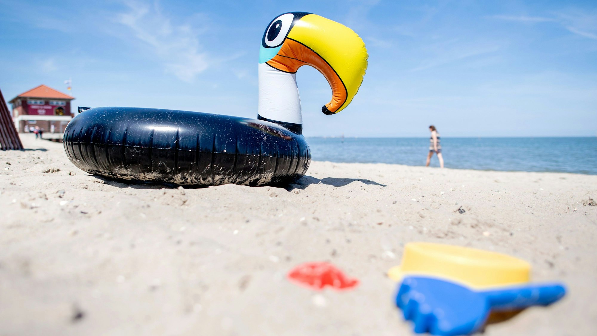 Ein Schwimmtier und Sandspielzeuge liegen im Sand. (Symbolbild)
