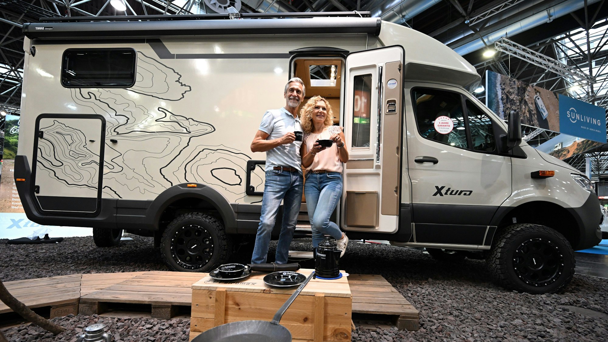 Die Models Andreas (l.) und Anja stehen vor einem Offroader Xtura der Firma Eura Mobil.