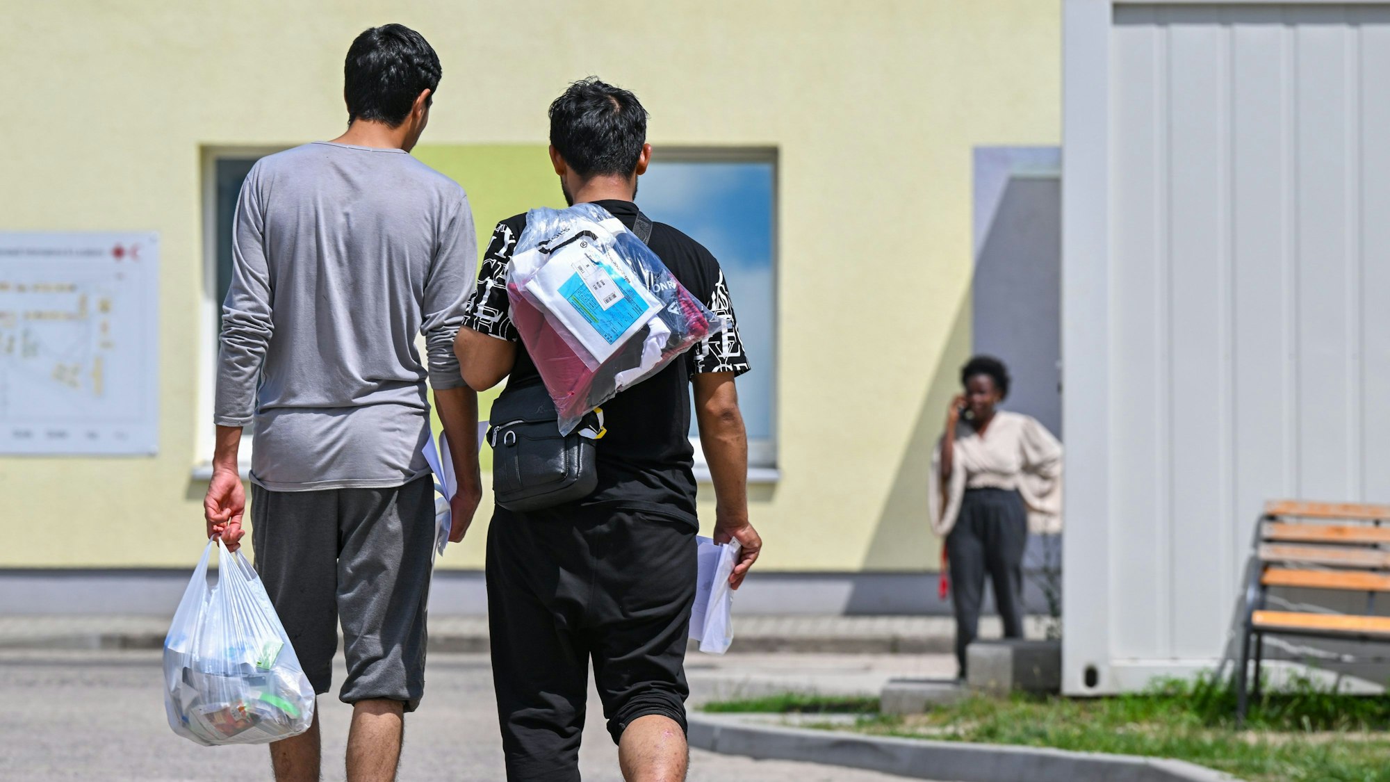 Zwei Migranten gehen über das Gelände der Zentralen Erstaufnahmeeinrichtung für Asylbewerber.