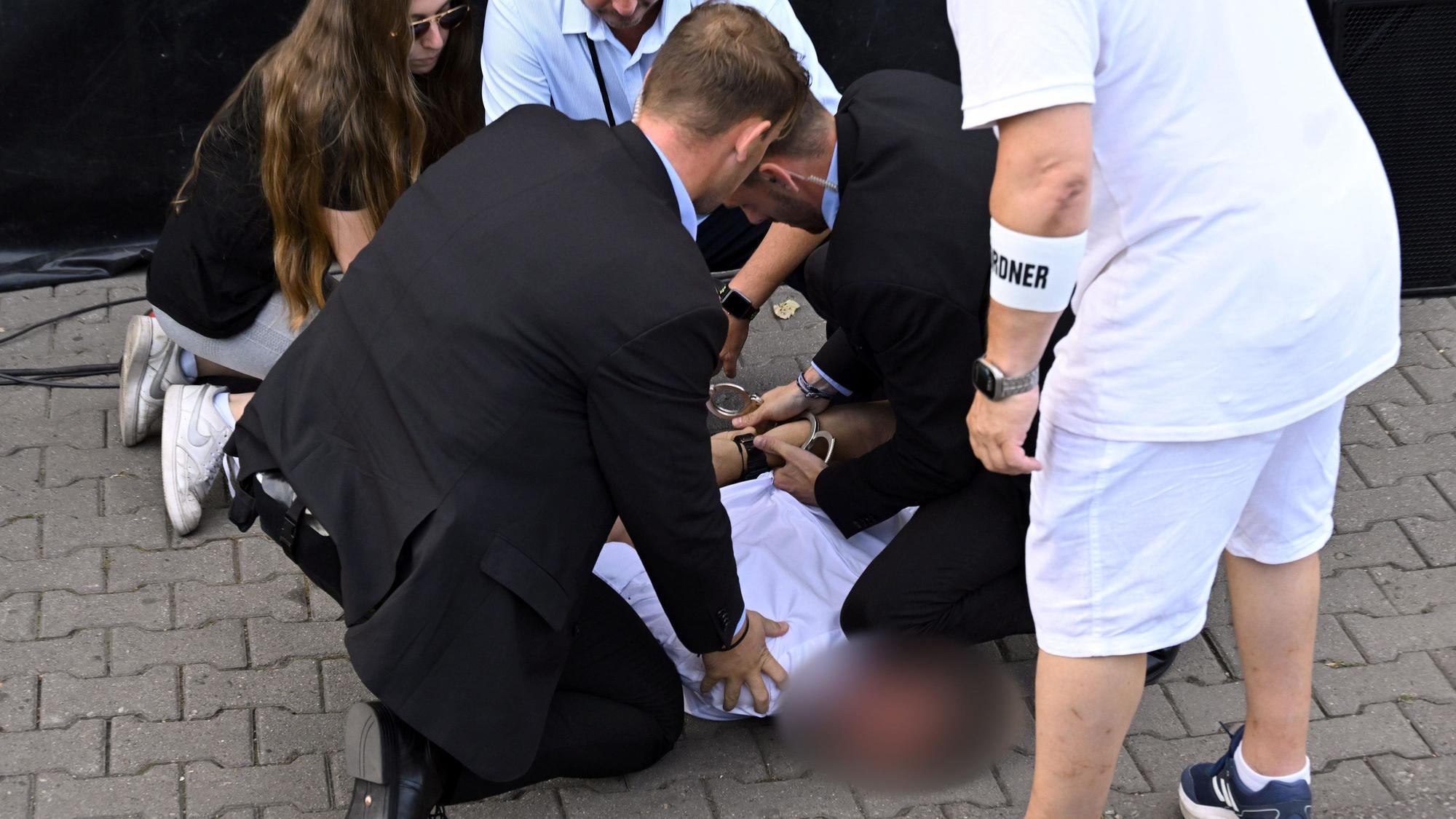 Personenschützer setzen einen Mann am Boden fest, der bei einer Wahlkampf-Veranstaltung des Bündnis Sahra Wagenknecht (BSW) auf dem Domplatz in Erfurt einen Angriff mit roter Farbe ausgeübt haben soll.