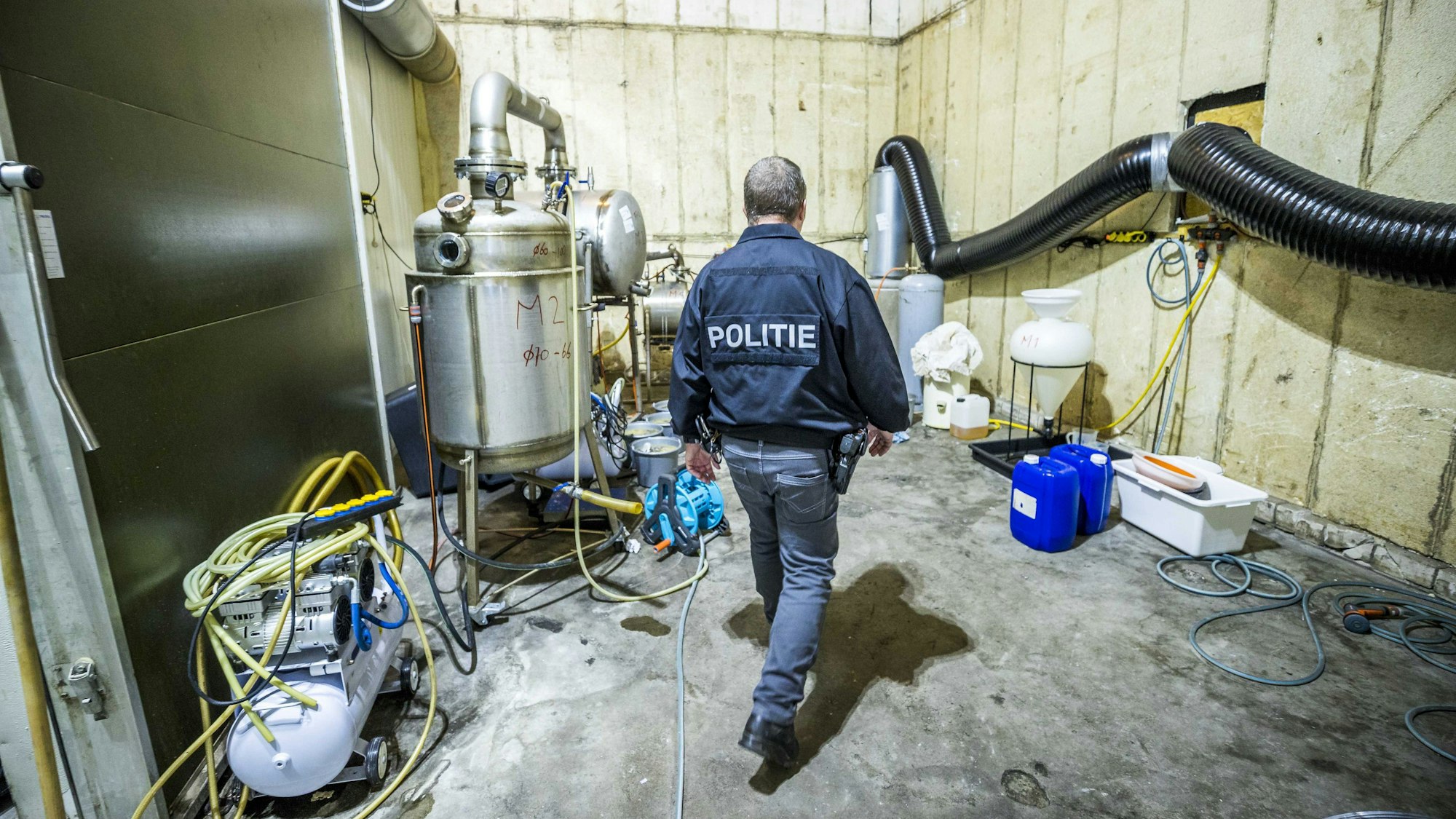 Ein Polizist führt Ermittlungsarbeiten in einem illegalen Crystal-Meth-Labor in den Niederlanden durch.