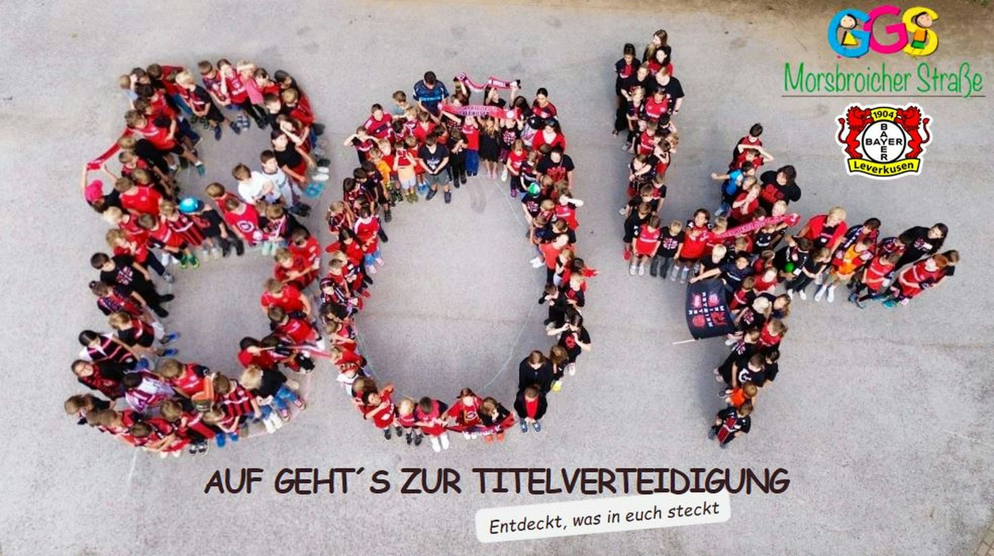 Die Kinder der Schlebuscher GGS Morsbroicher Straße haben sich auf dem Schulhof in schwarz-rot formiert