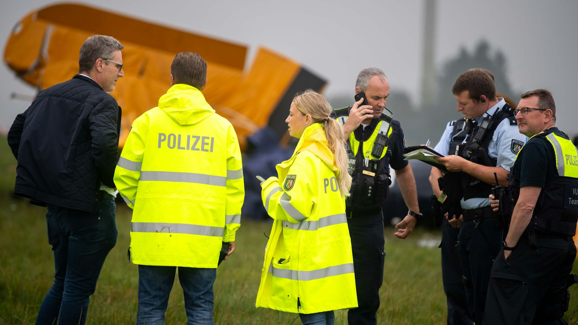Bei einem Flugzeugabsturz zwischen Engelgau und Frohngau ist eine Frau ums Leben gekommen. Mehrere Polizisten stehen vor der Maschine.