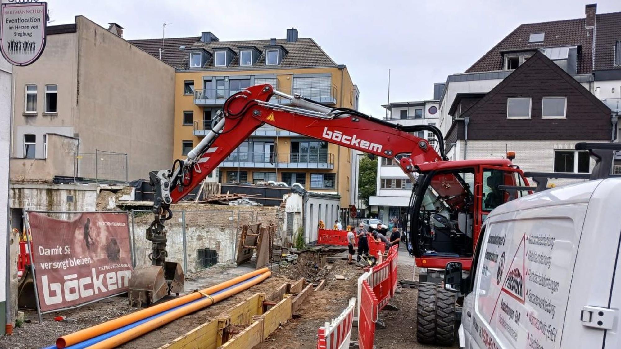 Ein Bagger neben einer Baugrube.