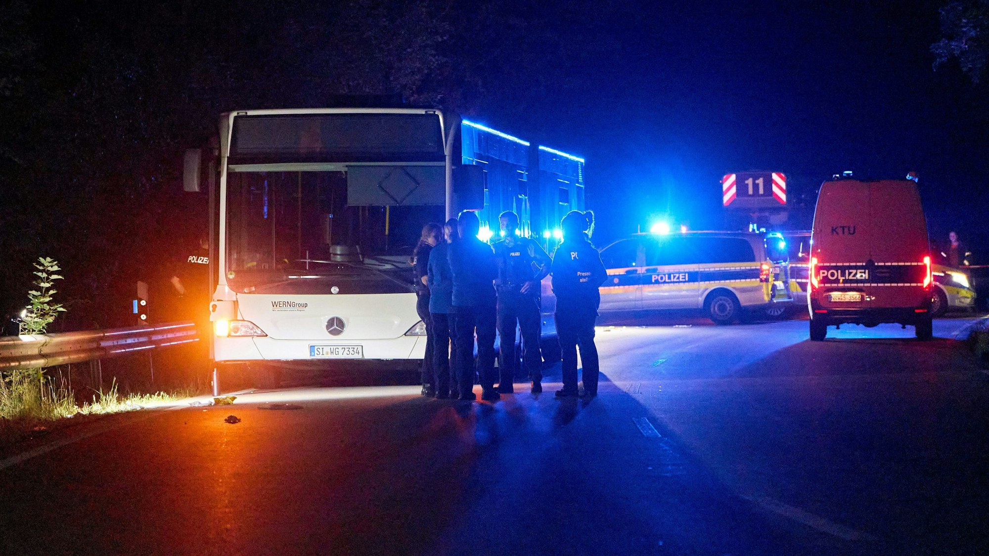 30.08.2024, Nordrhein-Westfalen, Siegen: Polizisten stehen vor einem Bus, der auf einer Sonderlinie zu einem Stadtfest fahren sollte. Eine 32-jährige Tatverdächtige habe in dem Bus andere Fahrgäste mutmaßlich mit einem Messer angegriffen. Es gebe mehrere Verletzte aber keinerlei Hinweise auf einen terroristischen Hintergrund, teilte die Polizei mit. Foto: Sascha Ditscher/dpa +++ dpa-Bildfunk +++