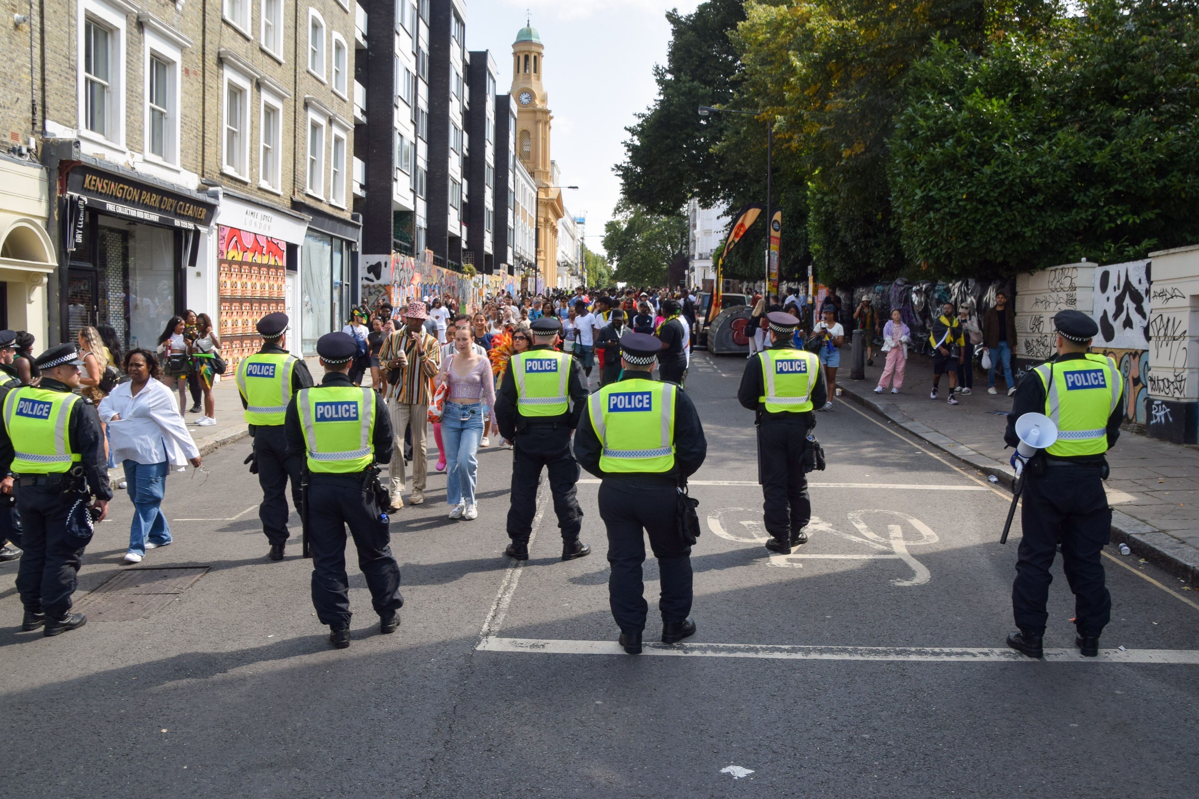 Polizeibeamte beobachten die Menschenmenge am zweiten Tag des Notting Hill Carnival. Die jährliche Veranstaltung in Londons beliebtem Stadtteil Notting Hill zieht rund eine Million Menschen an und ist vor allem ein Fest der karibischen Kultur.