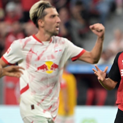 Leverkusens Florian Wirtz (r) und Leipzigs Kevin Kampl reagieren auf dem Feld.