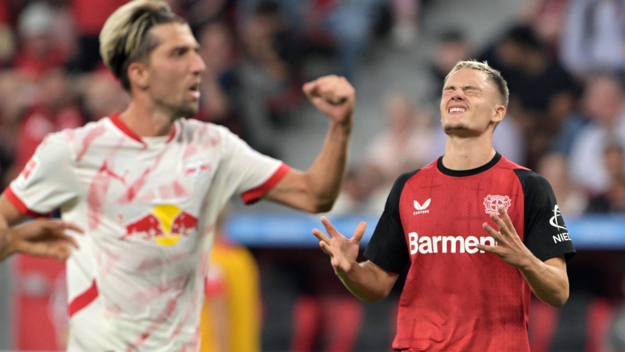 Leverkusens Florian Wirtz (r) und Leipzigs Kevin Kampl reagieren auf dem Feld.