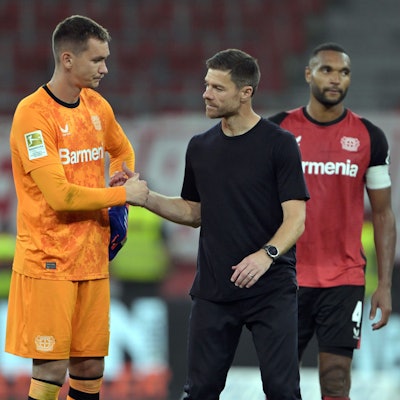 Leverkusens Arthur (l-r), Torwart Matej Kovar, Trainer Xabi Alonso und Jonathan Tah stehen nach dem Spiel auf dem Platz.