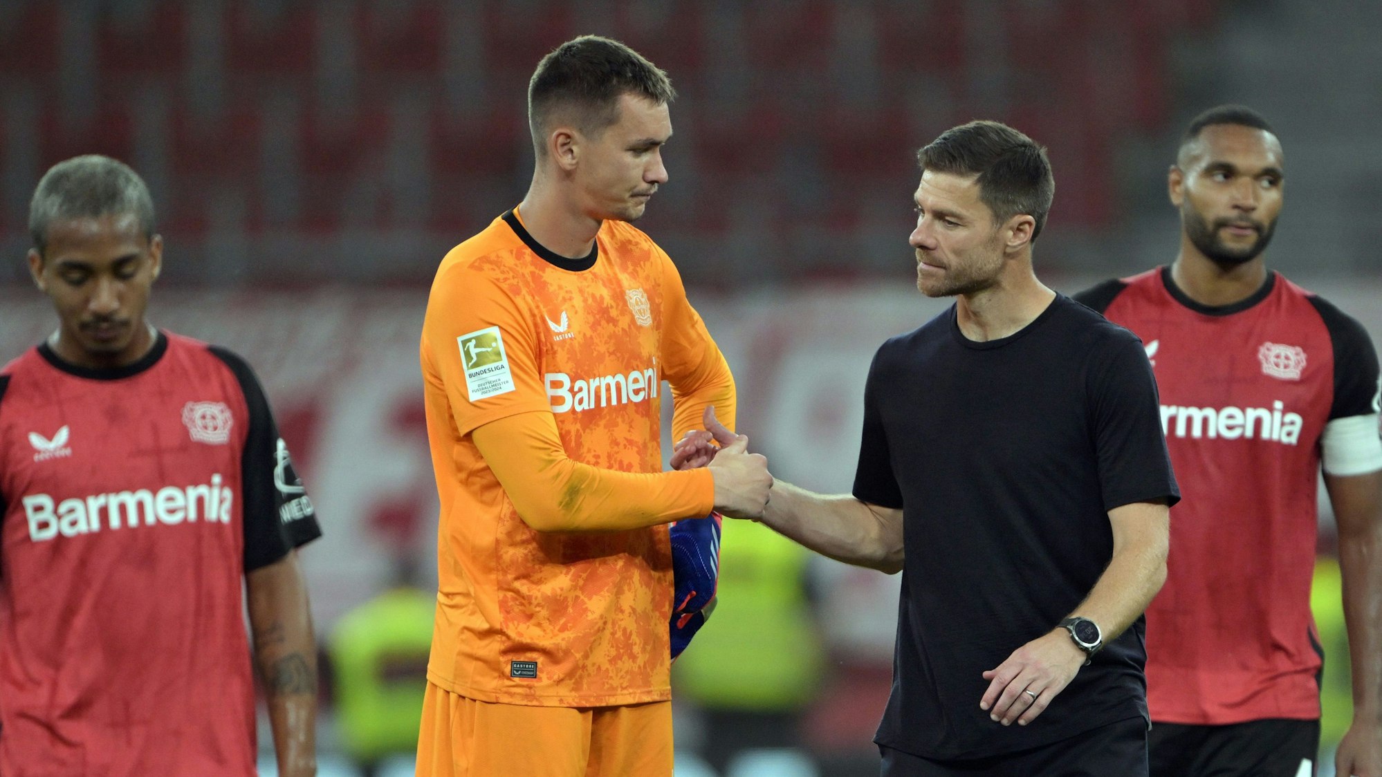Leverkusens Arthur (l-r), Torwart Matej Kovar, Trainer Xabi Alonso und Jonathan Tah stehen nach dem Spiel auf dem Platz.
