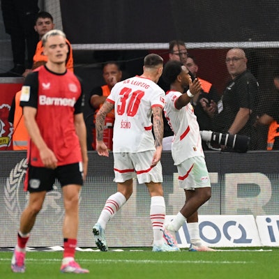 Lois Openda jubelt über das Tor zum 2:2 gegen Bayer Leverkusen und Florian Wirtz (l.).