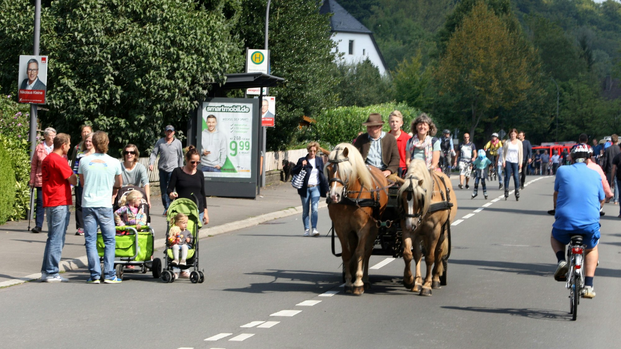 Fußgänger, Radfahrer und eine Pferdekutsche nutzen die autofreie Landstraße im Strundetal.