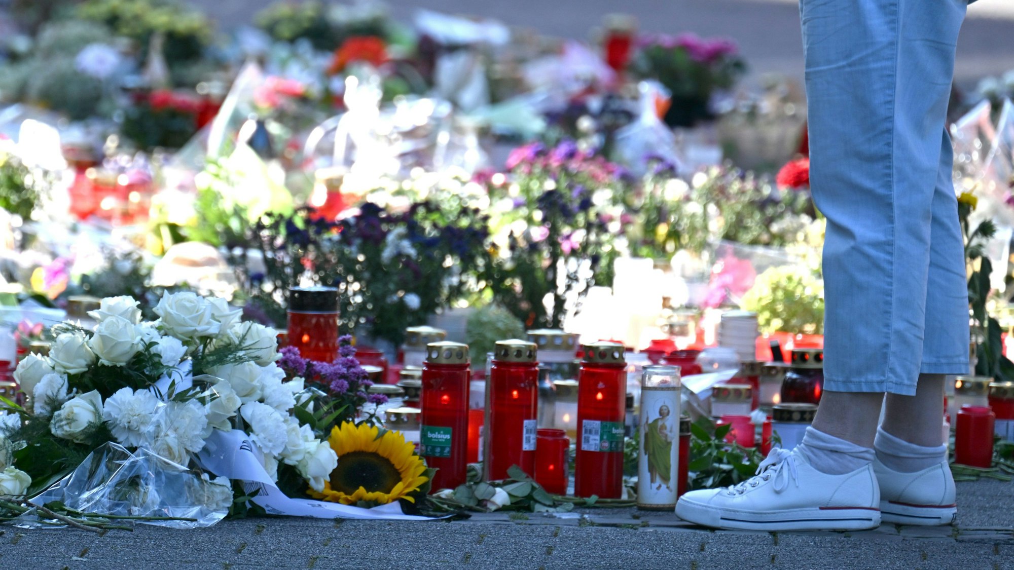 Blumen und Kerzen sind in der Nähe des Tatortes abgelegt worden. Am Freitagabend (23.08.2024) waren bei einem Stadtfest im nordrhein-westfälischen Solingen drei Menschen mit einem Messer getötet worden. (Archivbild)