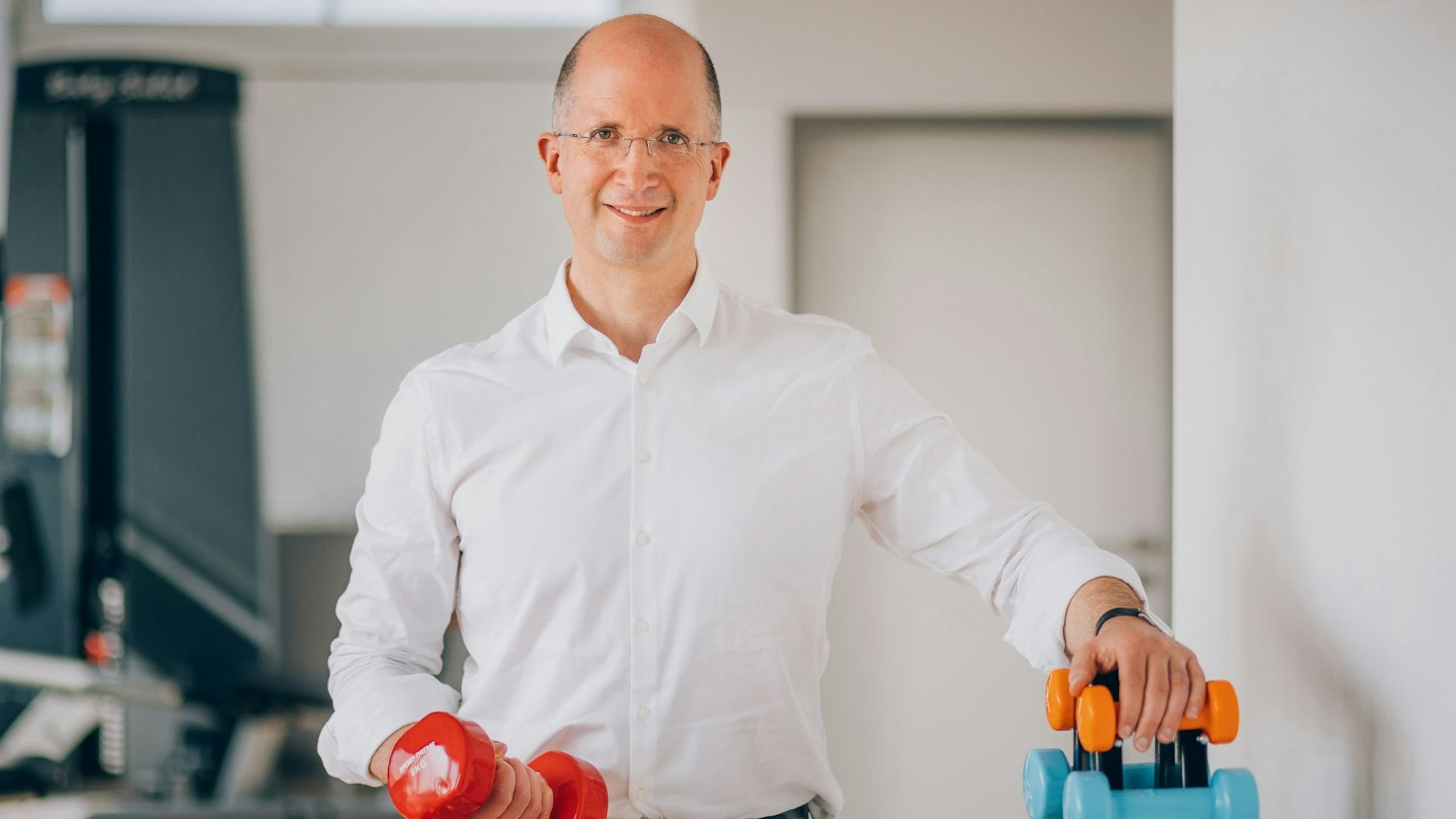 Thorsten Latzel, Präses der Evangelischen Kirche im Rheinland, mit Fitness-Gewichten. Latzel ist auch Sportbeauftragter der EKD