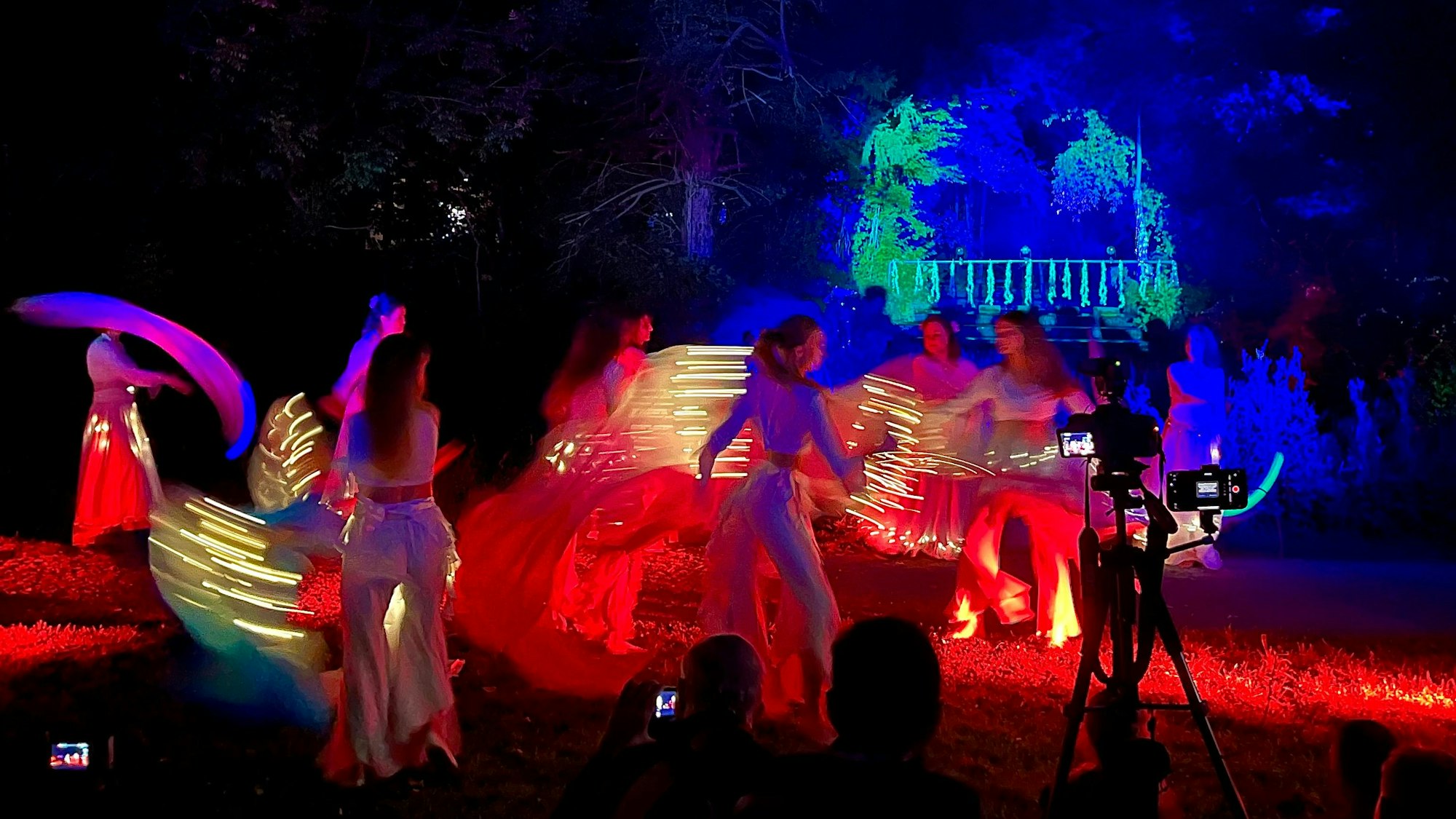 Beleuchtete Kostüme im beleuchteten Schlosspark.