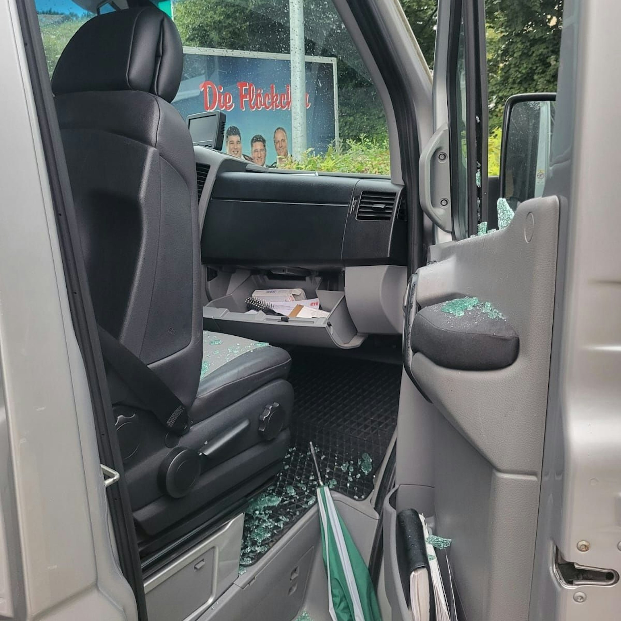 Die Beifahrerscheibe eines VW-Crafters der Musikgruppe „Die Flöckchen“ ist eingeschlagen, auf dem Boden liegen Glassplitter, das Handschuhfach ist aufgebrochen und durchwühlt.