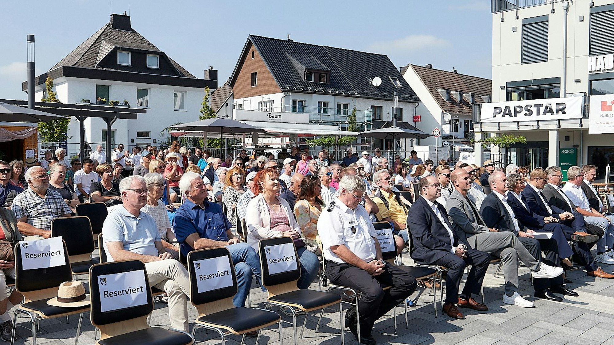 Die Teilnehmer sitzen auf den Stühlen, die in mehreren Reihen aufgestellt worden waren.