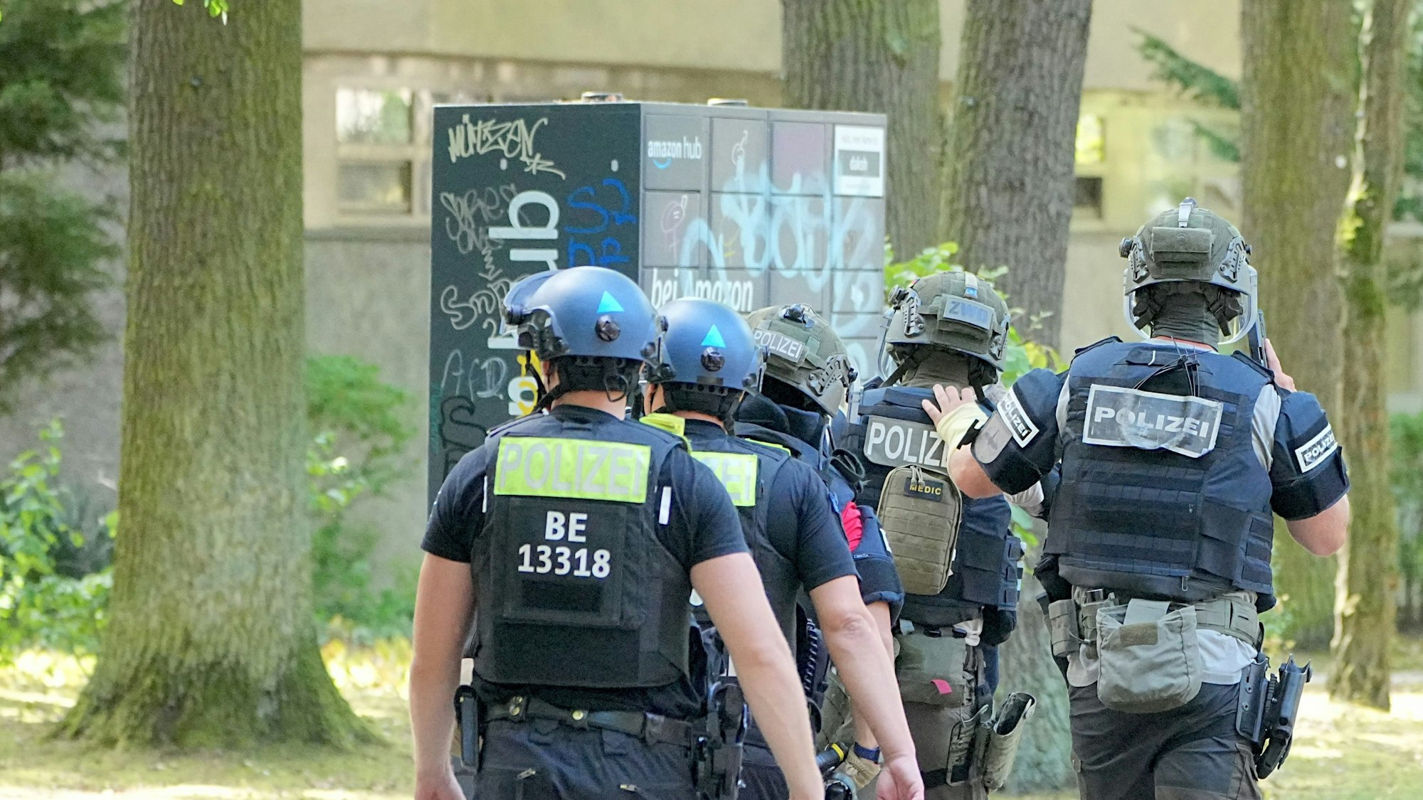 Polizisten eines Spezialeinsatzkommandos (SEK) gehen zu einem Mehrfamilienhaus in Berlin Nikolassee.